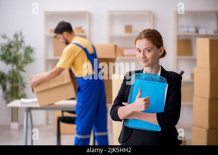 Weibliche Chefin und männliche Fremdfirma, die Hausverlagerungen machen Stockfoto