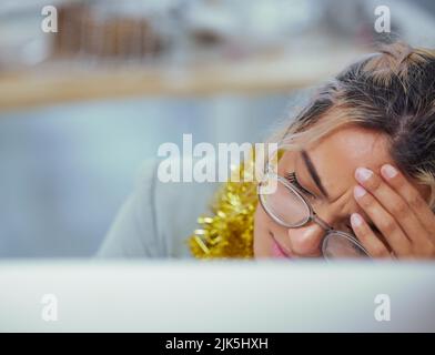 Eine junge Frau, die an ihrem Schreibtisch im Büro unter starken Kopfschmerzen leidet, hätte diese Schmerzmittel greifen sollen. Stockfoto