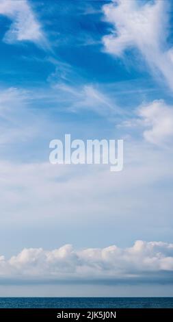 VERTIKALES PANORAMA echtes Foto natürliche Wolkenlandschaft Tapete. Schöne weiße flauschige Cumulus Wolken Sommer blauen Himmel ruhigen Meer Horizont Skyline. Konzept Stockfoto