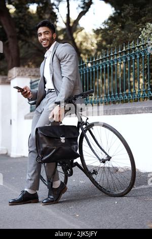 HES bereit, den Tag zu nehmen. Ein junger Geschäftsmann mit einem Telefon in der Stadt. Stockfoto