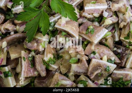 Koriander Schweinehren Salat ist ein traditionelles portugiesisches Gericht (orelhas de porco de coentrada), das aus Schweinehren und Koriander besteht. Andere Zutaten gehackt Stockfoto