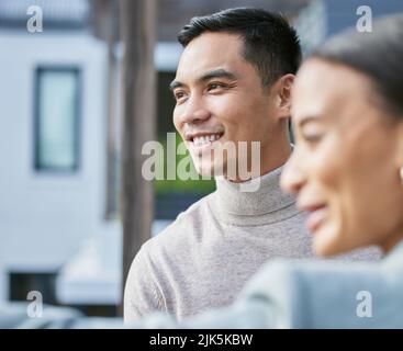 Es gibt tolle Aussichten. Eine junge weibliche Immobilienmaklerin zeigt einem Kunden ein Haus. Stockfoto