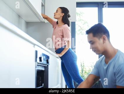 Ein junges Paar putzt gemeinsam ihre Küche. Stockfoto