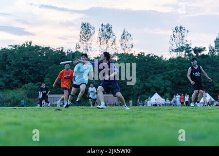 HEFEI, CHINA - 30. JULI 2022 - auf dem Campingplatz in Hefei, Anhui Provinc, treten Frisbee-Enthusiasten beim ultimativen Frisbee-Hybrid-Wettbewerb für 5 Personen an Stockfoto