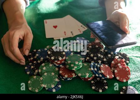 Eine Frau spielt in einem Casino. Öffnen von Karten, um Wetten zu erhöhen. Vor dem Hintergrund von Chips. Poker-Sieg Stockfoto