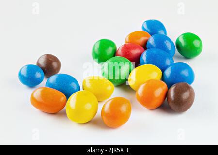 Bunte Schokoladen-Knöpfe, auf weißem Hintergrund. Schokoladenbeschichtete Erdnüsse. Stockfoto