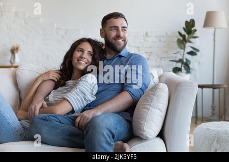 Fröhlich verträumt junge Dating-Paar in der Liebe ruht auf dem Sofa Stockfoto