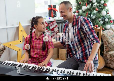 Vater und Tochter spielen zu weihnachten Klavier Stockfoto