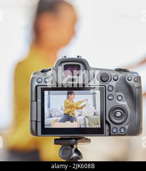 Ich habe ein paar Dinge, die ich zeigen möchte: Eine junge Frau, die zu Hause ein Video für ihren Vlog aufzeichnet. Stockfoto