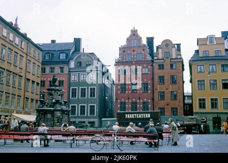 Blick auf Stortorget (oder Börsenplatz), einen öffentlichen Platz in Gamla Stan, der Altstadt von Stockholm, Schweden im Jahr 1970. Es ist der älteste Platz in Stockholm, das historische Zentrum. Es ist traditionell bekannt für seinen jährlichen Weihnachtsmarkt, der traditionelles Kunsthandwerk und Speisen anbietet. Der Brunnen auf dem Platz wurde auch von Palmstedt entworfen. Dieses Bild stammt von einer Amateur-35mm-Farbtransparenz – einem klassischen 1970er-Foto. Stockfoto