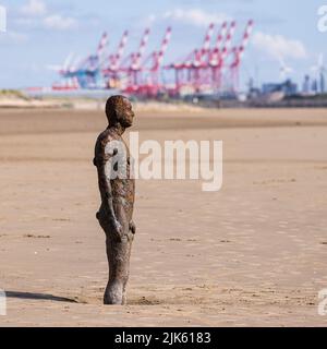 Ein weiterer Ort von Antony Gormley am Crosby Beach bei Ebbe mit Liverpool Docks im Hintergrund Stockfoto