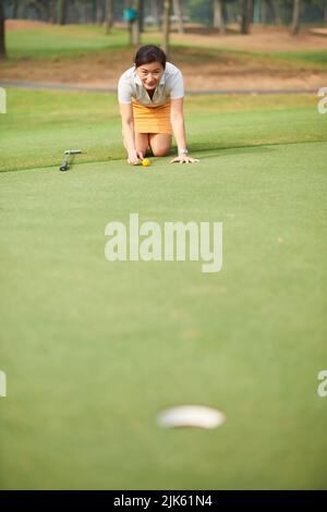 Weibliche Golfspielerin, die nach der besten Position für den Finishing Hit sucht Stockfoto