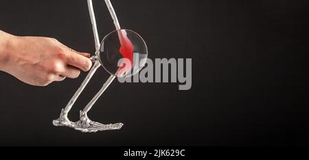 Banner mit Hand mit Lupe über Patella des menschlichen Skeletts mit roter Spitze. Knieschmerzen. Verstauchte Bänder, Meniskusriss, Sehnenentzündung, Dislokation. Speicherplatz kopieren. Hochwertige Fotos Stockfoto