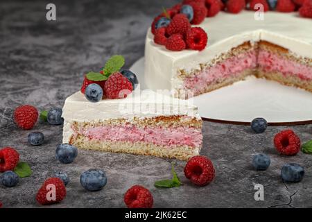 Köstlicher Himbeerkuchen mit Rahm und dekoriert mit frischen Himbeer-Beeren und Minzblättern Stockfoto