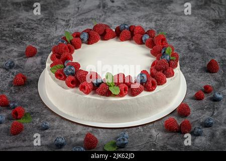 Köstlicher Himbeerkuchen mit Rahm und dekoriert mit frischen Himbeer-Beeren und Minzblättern Stockfoto