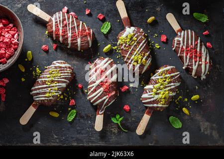 Köstliche und hausgemachte Eis mit Früchten und Schokoladenüberzug. Popsicles als kleiner perfekter Snack. Stockfoto