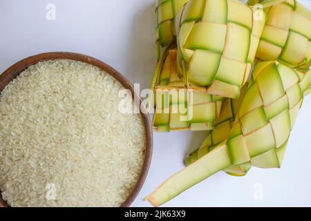 Ketupat in Steingutplatte isoliert auf weißem Hintergrund. Ketupat (Reisknödel) ist ein Essen, das serviert wird, wenn idhul fitri (eid mubarak) in Indonesien, Fr. Stockfoto