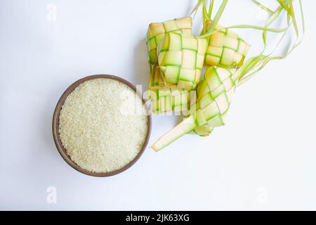 Ketupat in Steingutplatte isoliert auf weißem Hintergrund. Ketupat (Reisknödel) ist ein Essen, das serviert wird, wenn idhul fitri (eid mubarak) in Indonesien, Fr. Stockfoto