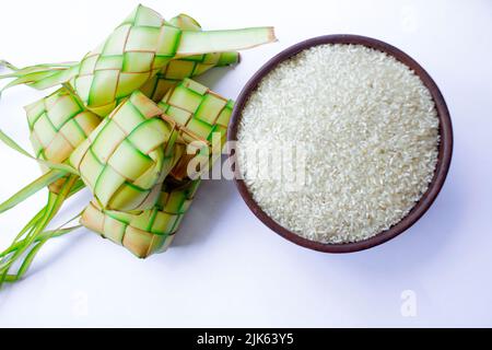 Ketupat in Steingutplatte isoliert auf weißem Hintergrund. Ketupat (Reisknödel) ist ein Essen, das serviert wird, wenn idhul fitri (eid mubarak) in Indonesien, Fr. Stockfoto