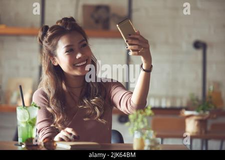 Glückliche hübsche vietnamesische junge Frau, die Selfie macht Stockfoto