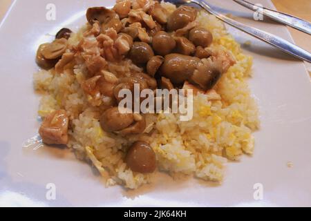 Hainanesischer Hühnerreis oder hainan-Reis oder Nasi ayam hainan, serviert mit Pilzen im Restaurant Stockfoto