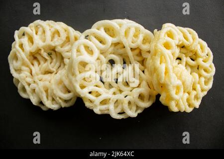 Kerupuk oder Krupuk oder Cracker isoliert auf schwarzem Hintergrund. Kerupuk ist Snacks aus Tapioka Mehlteig mit Geschmackstoffen wie Garnelen oder Fi gemischt Stockfoto