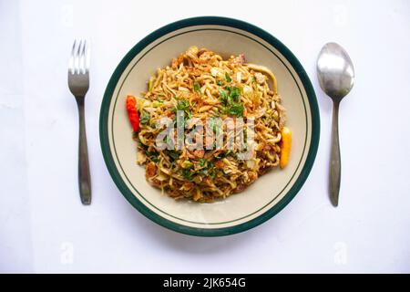 'Mie Goreng Jawa oder Bakmi jawa oder java Nudel mit Löffel und Gabel. Indonesische traditionelle Street Food Nudeln aus Zentral-java oder Yogyakarta, Indone Stockfoto