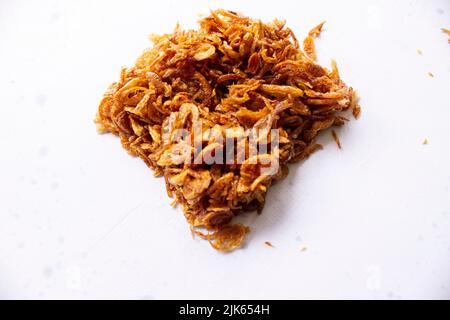 bawang goreng oder Haufen gebratener indonesischer Fritten oder Schalotten mit kreisförmiger Isolierung auf weißem Hintergrund. Stockfoto