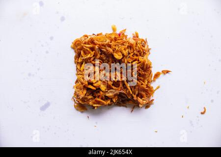 bawang goreng oder Haufen gebratener indonesischer Fritten oder Schalotten mit kreisförmiger Isolierung auf weißem Hintergrund. Stockfoto