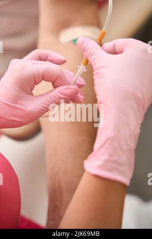 Weibliche Hände der Krankenschwester halten Dropper in ihren Händen Stockfoto