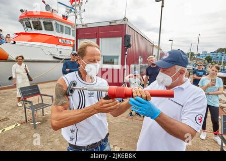 31. Juli 2022, Schleswig-Holstein, Laboe: Martin Bahr (l), Mitarbeiter und Besucher, lässt ihm am Sea Rescue Day 2022 im Hafen von Laboe das Linienschießgerät PLTR-75 von Uwe Radloff, Vorarbeiter des Seerettungskreuzers 'Berlin', erklären. Mit dem pneumatischen Leitungsschießgerät mit 90-m-Leitung wird eine Leitungsverbindung zu einem verletzten Schiff auf See hergestellt. Nach zwei Jahren veranstaltete der Deutsche Seerechtungsdienst (DGzRS) erneut den Tag der Seeretter 2022 an verschiedenen DGzRS-Stationen mit Präsentationen der Rettungstechnik, Mann-über-Bord-Übungen und Vorführungen der Rettungsaktion Stockfoto