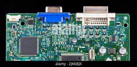 Grünes Leiterplattendetail isoliert auf schwarzem Panorama-Hintergrund. Verschiedene elektronische Komponenten wie Chip, Transistor oder Kristall. SMD-Geräte. Stockfoto