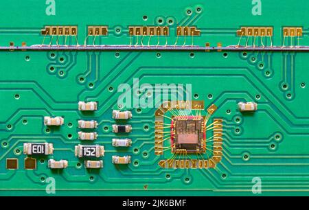 Integrierte Leiterplattendüse mit grüner Leiterplattenstruktur und Zeilenkamera. Nahaufnahme des Chips, der durch Golddrähte mit der Leiterplatte im Flachbettscanner verbunden ist. Stockfoto