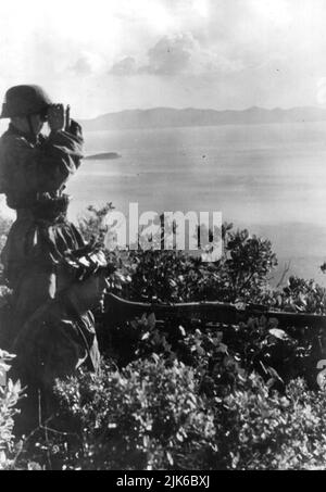 Die Nazi-deutschen Elitetruppen der Waffen-SS hatten viele Abteilungen ausländischer Freiwilliger, die an den nationalsozialismus glaubten. Zwei Soldaten der SS Volunteer Mountain Division Prinz Eugen 7. mit ihrem MG 42 Maschinengewehr an der dalmatinischen Küste, 1943 Stockfoto