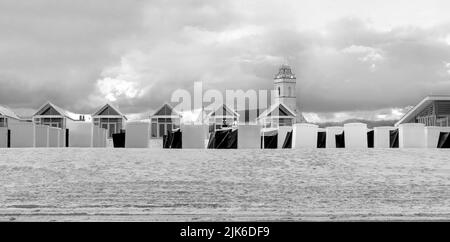 Blick vom Strand auf Chalets und Strandhütten und Andrew's Church in Katwijk, Südholland, Niederlande. Stockfoto