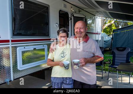 Glückliches pensioniertes Paar, das mit ihrem luxuriösen Wohnwagen im Mudjimba Caravan Park in Queensland campt Stockfoto