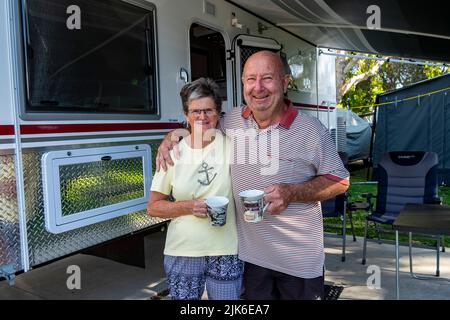 Glückliches pensioniertes Paar, das mit ihrem luxuriösen Wohnwagen im Mudjimba Caravan Park in Queensland campt Stockfoto