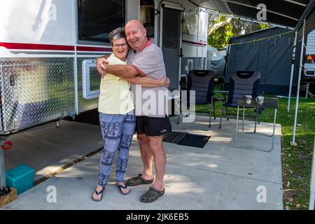 Glückliches pensioniertes Paar, das mit ihrem luxuriösen Wohnwagen im Mudjimba Caravan Park in Queensland campt Stockfoto