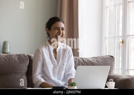 Fröhliche glückliche indische freiberufliche Mitarbeiterin Frau, die von zu Hause aus arbeitet Stockfoto