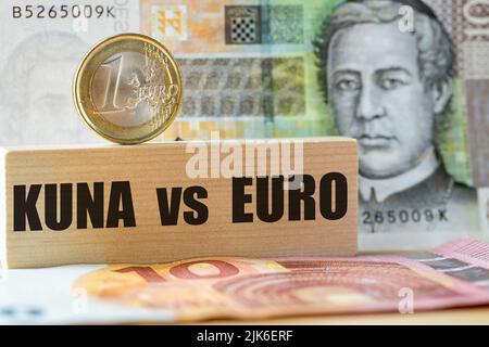 10 Kuna-Banknote, 1-Euro-Münze auf Holzblock, geschrieben Kuna vs Euro, Konzept, kroatischer Währungswechsel in Euro, Kroatiens Eintritt in den Euro zo Stockfoto