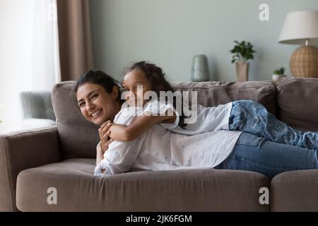 Glücklich süß indisch Kind Mädchen ruht auf glücklich Mütter zurück Stockfoto