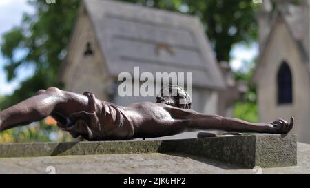 Statue von Jesus Kruzifix auf einem Grabstein Stockfoto