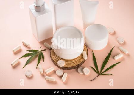 CBD-Öl in Glasflaschen und Cannabisblätter am weißen Tisch. Stockfoto