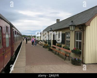 Der Zug fuhr am Bahnsteig an einer Station der Strathspey Heritage Steam Railway, die von Aviemore - Boat of Garten - Broomhill fährt. Stockfoto