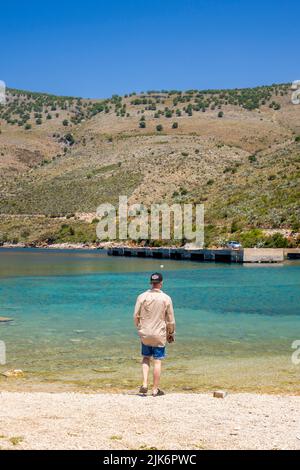 Porto palermo Albanien - 12.05.2021: Mann von hinten beobachtet die Bucht von Porto palermo in Albanien Stockfoto