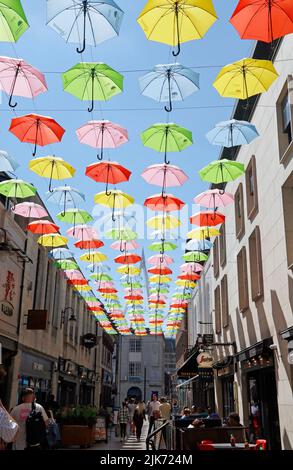 Farbenfrohe, hängende Dachschirmanzeige mit blauem Himmel. Cardiff Scenes, Juli 2022. Sommer. Admiral-Versicherungslogos. Stockfoto