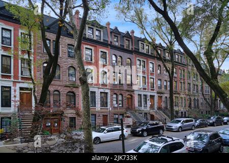 Wohnstraße in New York mit einer langen Reihe alter Sandsteinhäuser Stockfoto