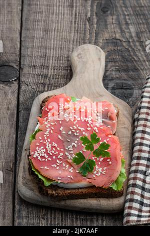Gesundes Toast mit Roggenbrot und Lachs auf Holztisch Stockfoto
