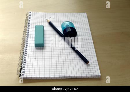 Schreibutensilien: Bleistift, Spitzer und Radierer auf einem karierten Pad Stockfoto