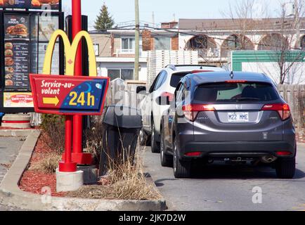 Montreal, Kanada - 4. April 2022: McDonald's Drive mcdrive-Logo mit Autos in der Schlange. McDonald's ist die nach Umsatz größte Restaurantkette der Welt, Serv Stockfoto